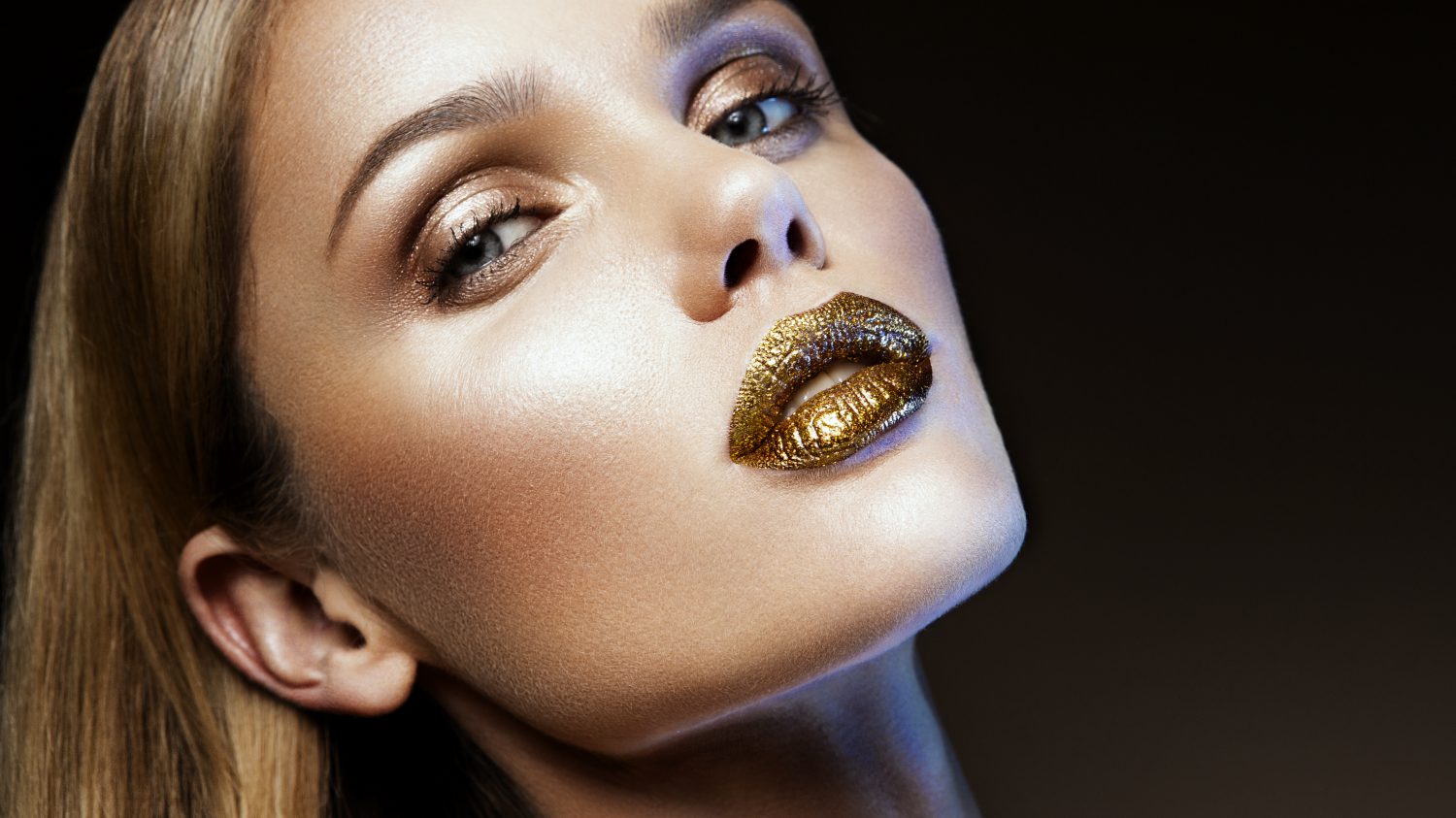 Beautyful girl with gold glitter on her face and body